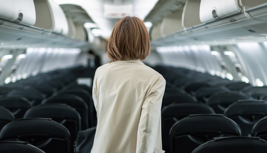 A woman boards an empty plane. With incontinence, long trips can be a cause of anxiety.